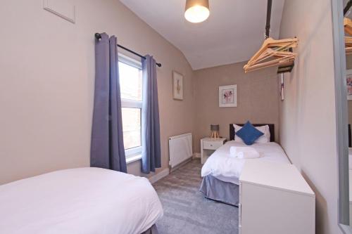 a bedroom with two beds and a window at Ashville Grange Scarborough Sleeps 10 Large Beautiful House in Scarborough