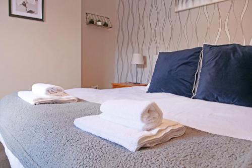 a white cat laying on towels on a bed at Ashville Grange Scarborough Sleeps 10 Large Beautiful House in Scarborough