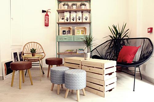 a living room with chairs and a wooden cabinet at Picnic Dreams Boutique Hostel in Málaga