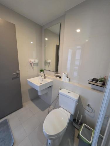 a bathroom with a white toilet and a sink at The Base Central Pattaya in Pattaya