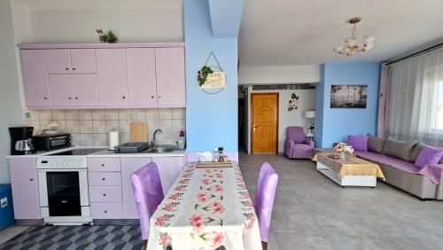 a kitchen and living room with a table and purple chairs at Mary's Apartment - Close to port, beaches in Kos