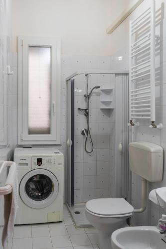 a bathroom with a washing machine and a toilet at 900 Dal Blu in Licata