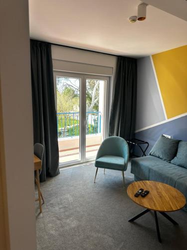a living room with a blue couch and a window at Hotel Elu Iris in Split