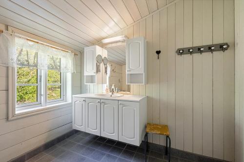 a white bathroom with a sink and a window at Kartveit Gjestetun in Manger