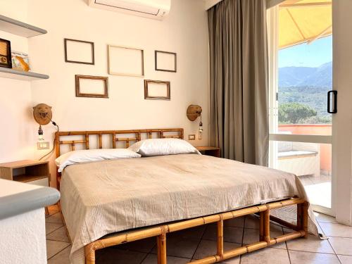 a bedroom with a bed and a large window at Le 3 case di Mia in Marciana Marina