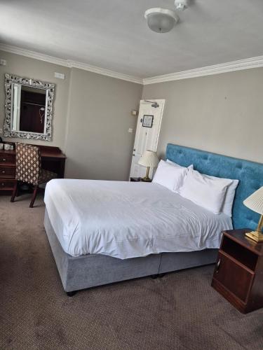 ein Schlafzimmer mit einem großen Bett mit blauem Kopfteil in der Unterkunft Imperial Accommodation Tralee in Tralee