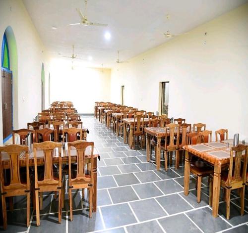 a room filled with wooden tables and chairs at Hostel Desert Camp Sam in Jaisalmer