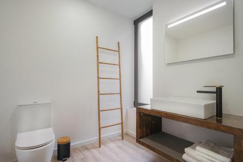 a bathroom with a toilet and a sink and a mirror at Blue Horizon Luxury Villa in Senhora do Rosário