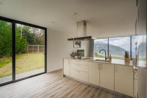a kitchen with white cabinets and a large window at Blue Horizon Luxury Villa in Senhora do Rosário
