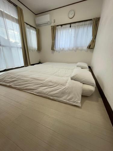 a bed in a room with two pillows on the floor at 古民家宿誠makoto in Tamano
