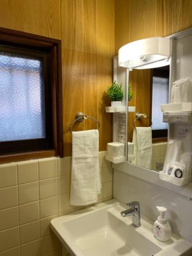 a bathroom with a sink and a mirror at 古民家宿誠makoto in Tamano