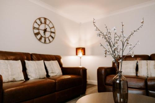 a living room with a couch and a vase with flowers at Buckthorn Grove - 4 bed stunning home in Middlesbrough