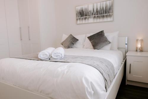 a bedroom with a white bed with towels on it at Buckthorn Grove - 4 bed stunning home in Middlesbrough