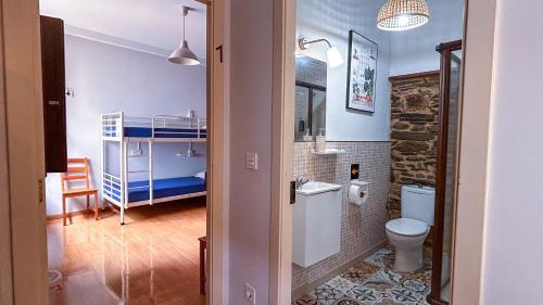 a bathroom with a toilet and a bunk bed at Albergue Mayor in Sarria