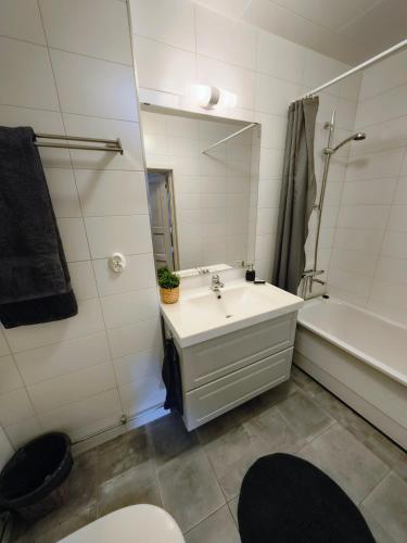 a bathroom with a sink and a tub and a mirror at Gästrum Vasaloppets vintervecka in Mora