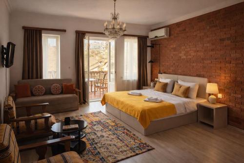 a bedroom with a bed and a brick wall at Tbil Inn Hotel in Tbilisi City