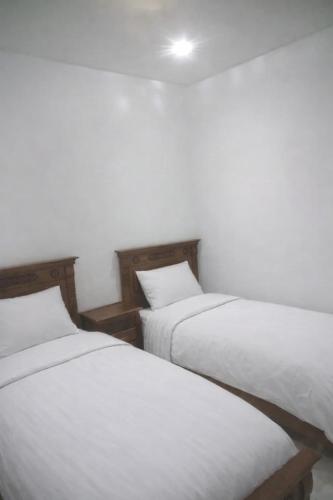 two twin beds in a room with white walls at Moroccan Inspired 2BR Bright, Central & New in Oulad Akkou