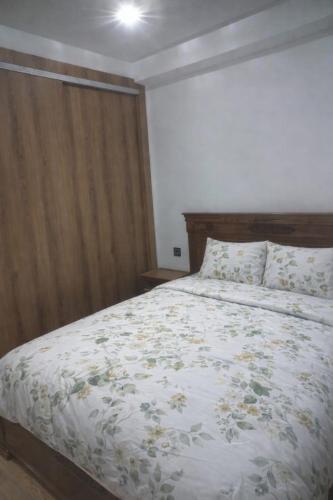 a bedroom with a bed with a floral comforter at Moroccan Inspired 2BR Bright, Central & New in Oulad Akkou