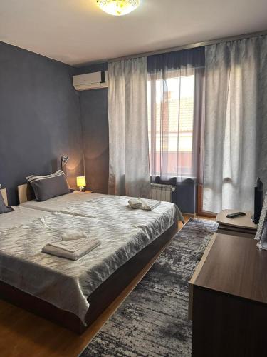 a bedroom with a large bed and a window at Gelov Hotel in Berkovitsa