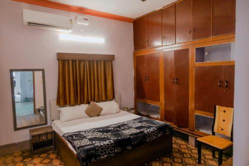 a bedroom with a bed and wooden cabinets and a mirror at Hotel The TWB palace in Gwalior