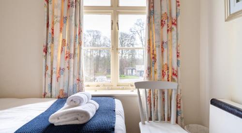a bedroom with a bed with towels on it at Greenhowes at the Graythwaite Estate in Ulverston