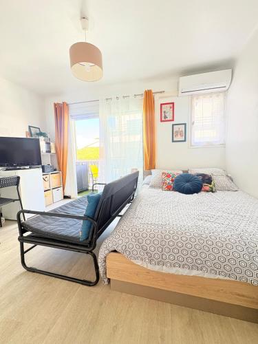 a bedroom with a bed and a chair at Studio à Canet Plage 200m Mer Balcon in Canet-en-Roussillon