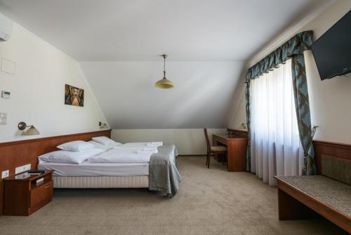 a hotel room with a bed and a window at Private Vendégház in Villány