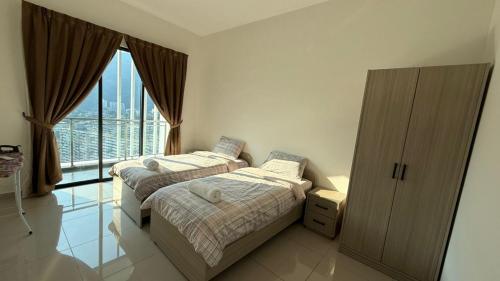 two beds in a room with a large window at Sunshine Residence in Ayer Itam