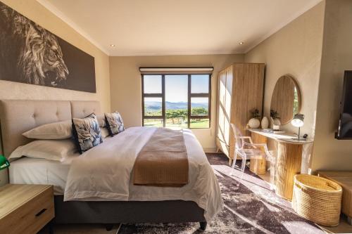 a bedroom with a large bed and a window at Rorkes Drift Lodge in Rorkeʼs Drift