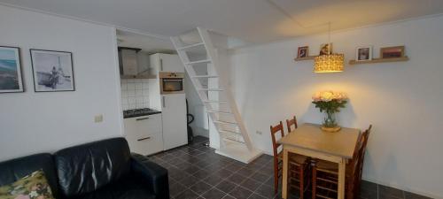 a living room with a couch and a table at Schrijvershuisje - sfeer & stilte Zeeuws Vlaanderen in Zaamslag