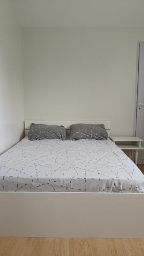 a bedroom with a bed with a white comforter at Chambre Deluxe avec Salle de bain et clim in Bourges