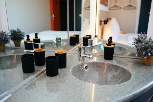 a bathroom counter with a sink and a mirror at Magnet Hotel in Schkeuditz