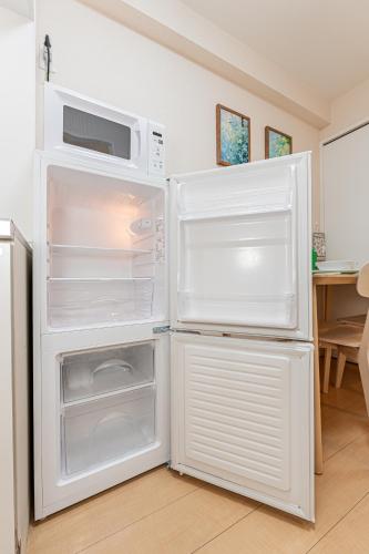 a white refrigerator with its door open in a kitchen at Home Story in Tokyo Hirai&新宿-Ueno-秋葉原まで直通&東京屋語 in Tokyo