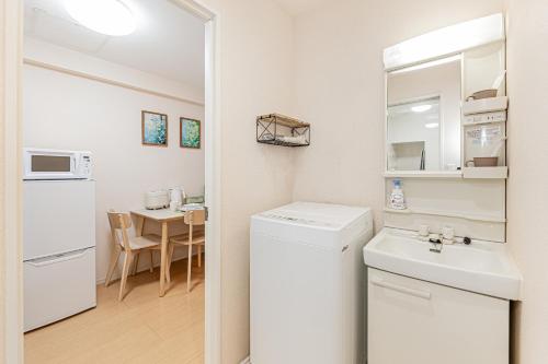 a small kitchen with a white refrigerator and a sink at Home Story in Tokyo Hirai&新宿-Ueno-秋葉原まで直通&東京屋語 in Tokyo