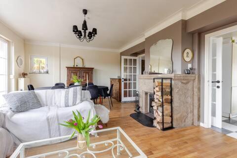 a living room with a white couch and a fireplace at La Villa des Hauts Chênes in Bouillon