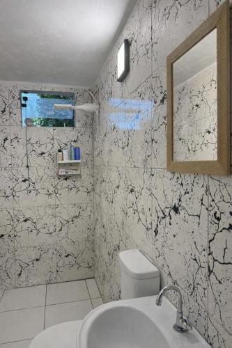 a bathroom with a toilet and a sink and a mirror at Casa Medrado in Porto Seguro