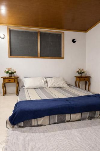 a bedroom with a large bed with two tables at Casa Medrado in Porto Seguro