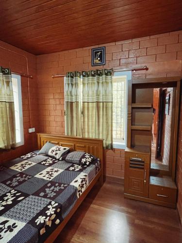 a bedroom with a bed and a dresser at Alloos homestay villa in Attappādi