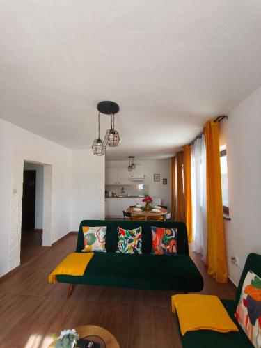a living room with a green couch and a table at Apartman Turkalj in Rakovica