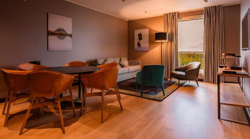 a living room with a table and chairs and a couch at Clarion Hotel Aviapolis in Vantaa