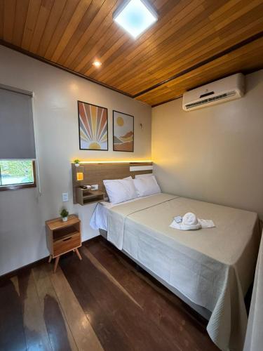 a bedroom with a large bed and a night stand at Econteiner Hotel Juruti in Juruti