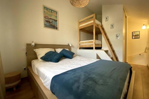 a bedroom with a bed with blue pillows on it at Air-conditioned house in the Arcachon style with swimming pool in La Teste-de-Buch