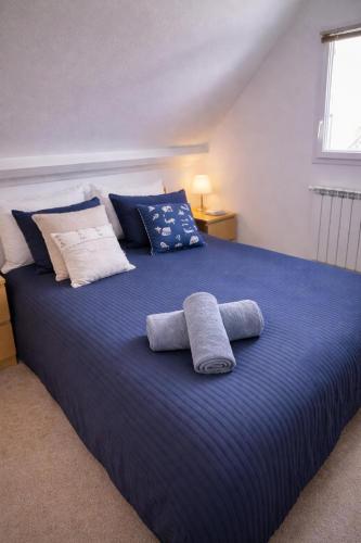 a large blue bed with two towels on it at Maisonnette cosy avec jardin - proche port et plage in Dives-sur-Mer