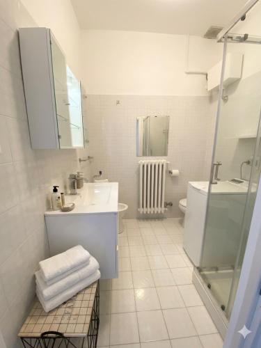 a white bathroom with a sink and a shower at Casa Matilde e Aurora GIARDINO e POSTO AUTO in Sirolo