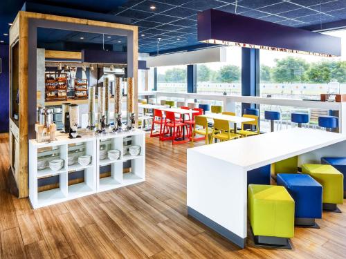 a restaurant with colorful chairs and tables at ibis budget Hotel Edinburgh Park in Edinburgh