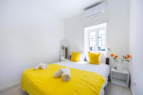 a bedroom with a yellow bed with towels on it at Casa do Vale in Paderne