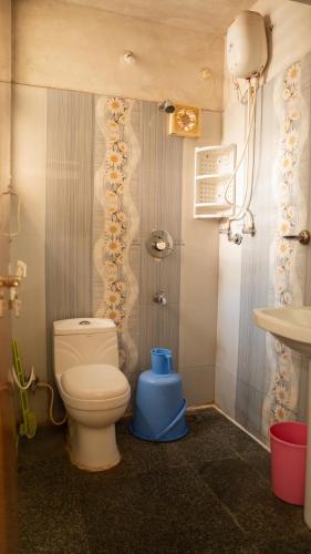 a bathroom with a toilet and a sink at DUDI's Stay in Mysore