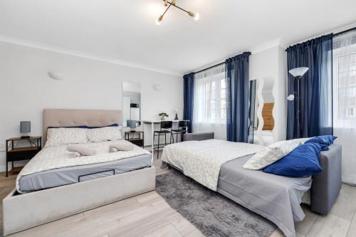 a bedroom with two beds and a dining room at Parkside Studio Retreat, 5 min from station ,R2 in London