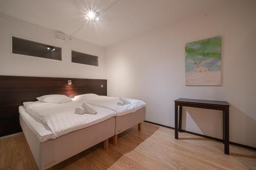 a bedroom with a bed and a table in it at City Centre Apartment Levi in Sirkka