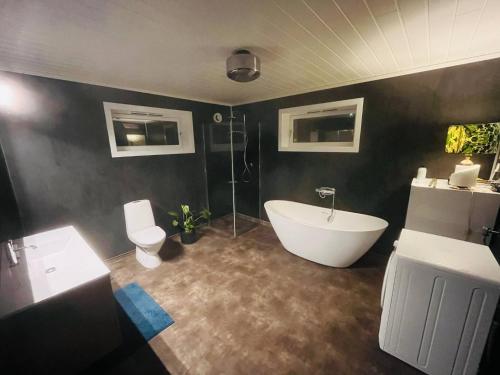a bathroom with a white tub and a toilet at Penthouse in Farsund in Farsund